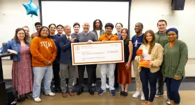 Brad Love in a group of students holding check