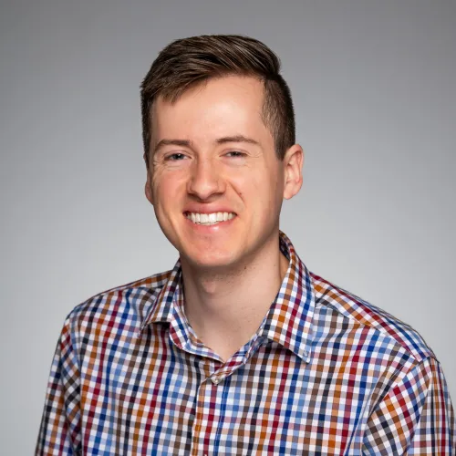 Headshot of Sean Tucker on a gray background. 