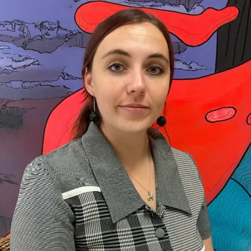 Taylor standing in front of a colored background