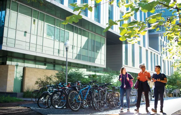 Three students standing in front of a building