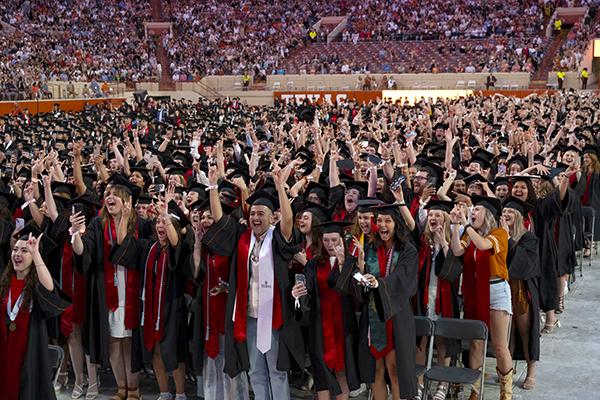 Students giving hook'em at graduation